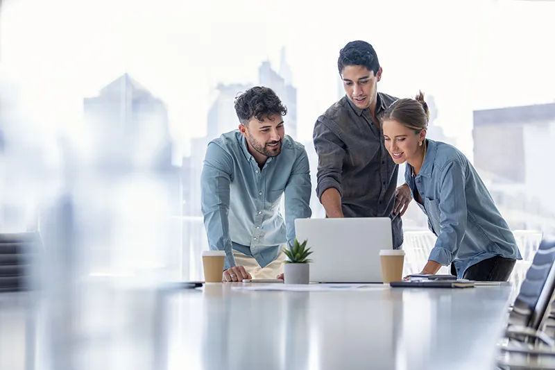 group-of-professionals-collaborating-and-discussing-together-around-a-laptop-in-an-office-setting