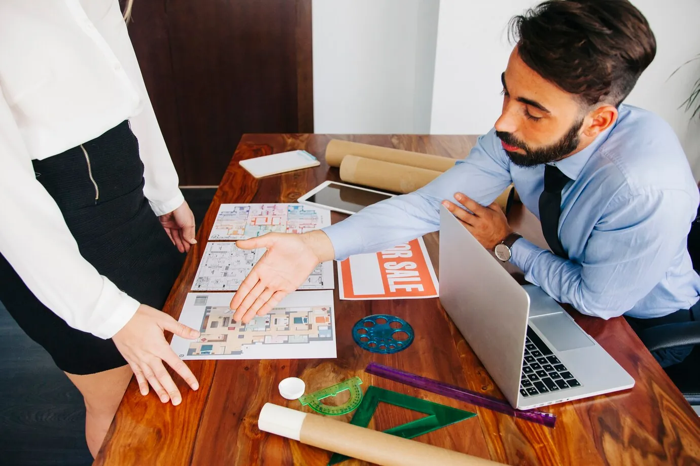real-estate-agent-discussing-property-with-client-using-floor-plans