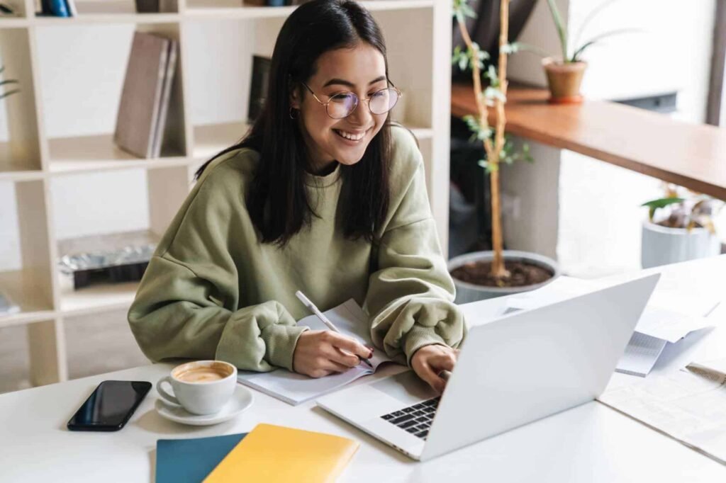 woman-working-on-laptop-with-notebook-and-coffee-finding-keyword-for-mental-health-site