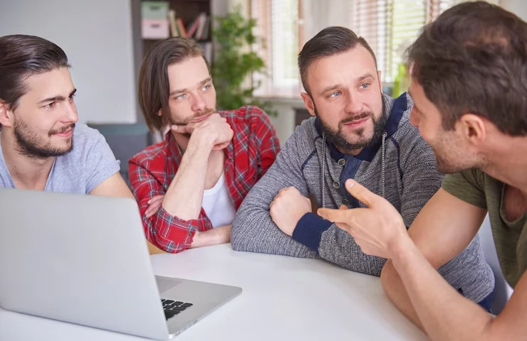 Group of professionals discussing over a laptop.
