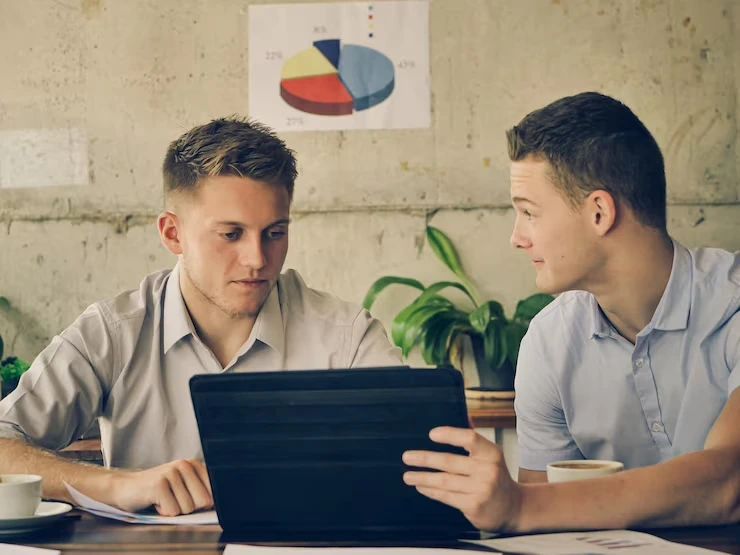 Two professionals reviewing WordPress analytics on a tablet, representing the best WordPress SEO services in Canada.