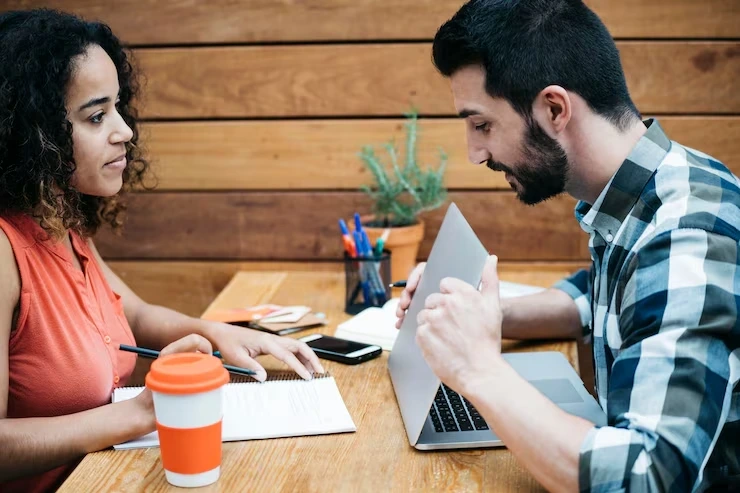 Two professionals discussing website content and structured data, representing businesses seeking FAQs, articles, and schema review support.