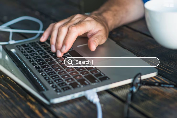 A marketing team discussing data at a desk with a laptop displaying analytics, representing keyword research services in Canada.