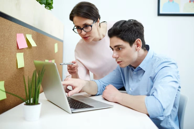 SEO experts researching and planning keyword strategy for a fabrication services website using a laptop.