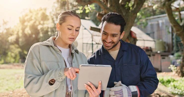 Two fabrication professionals reviewing outreach opportunities on a tablet to support link building campaigns.