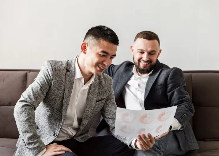 Two fabrication business professionals reviewing customer feedback and performance reports together.