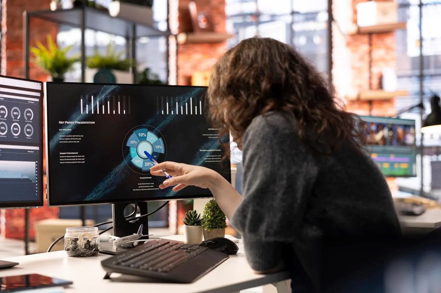 A professional analyzing performance dashboards on a monitor, representing ongoing schema monitoring and maintenance services.