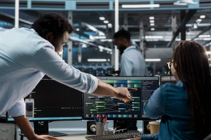 Technical professionals reviewing structured data outputs on dual monitors, representing businesses seeking expert Technical Implementation and Validation services.